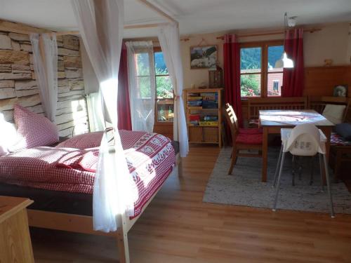 巴特欣德朗Alpakahof Wechs的卧室配有一张床和一张桌子及椅子