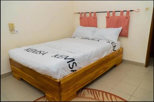 OuétoMaison d'hôte zouma的一间卧室配有一张木床,上面写着快乐的新年