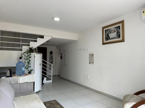 约恩维利Valentina Ramos Pousada - Joinville-SC的一间带冰箱和楼梯的客厅
