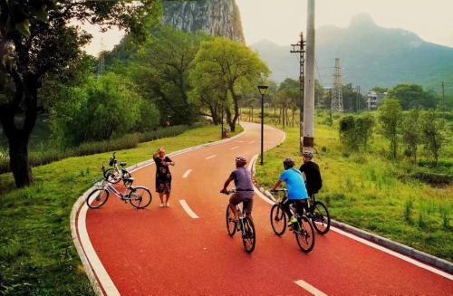 桂林Guilin Bonjour Boutique Hotel的一群人骑着自行车沿着马路