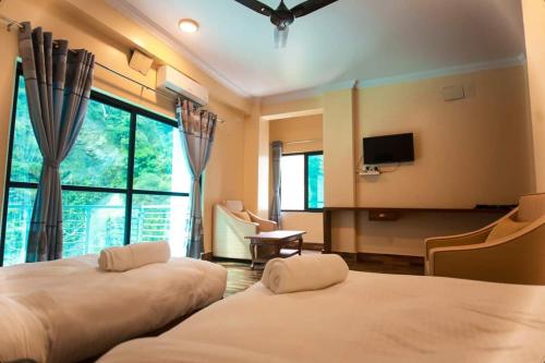 BeniShrestha Hotel Hotspring PVT.LTD的一间酒店客房,设有两张床和电视