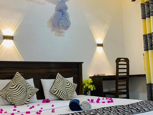 锡吉里亚Lucky Villa Sigiriya的一间卧室,床上有粉红色的鲜花