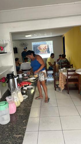 马塞约Pousada Água Viva的站在厨房准备食物的人