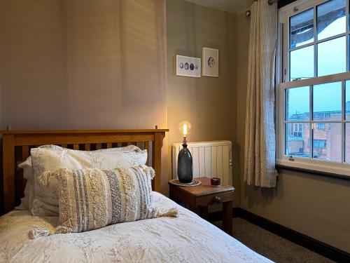 埃文河畔斯特拉特福The Hideaway的一间卧室配有一张带灯和窗户的床
