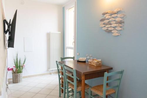 拉文纳Le Camere di Olivia的一间带木桌和蓝色椅子的用餐室