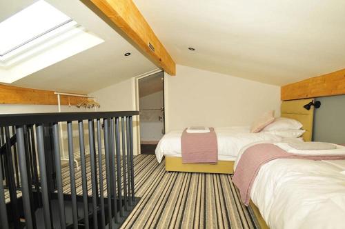 马奇温洛克Westwood Lodge的阁楼卧室设有两张床和天窗