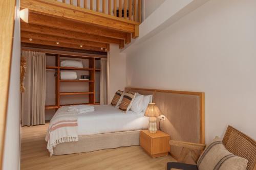 埃斯塔蒂特Marconia Boutique Residence的一间卧室配有一张床和一把椅子
