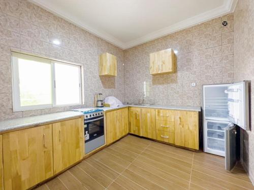 科托努GM IMMO SARL的厨房配有木制橱柜和冰箱。