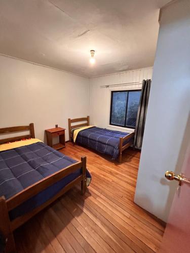 特木科Casa familiar的一间卧室设有两张床和窗户。