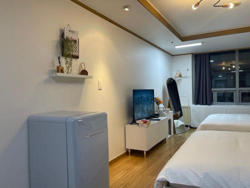 首尔Serein_HongDae的一间卧室配有两张床和电视。