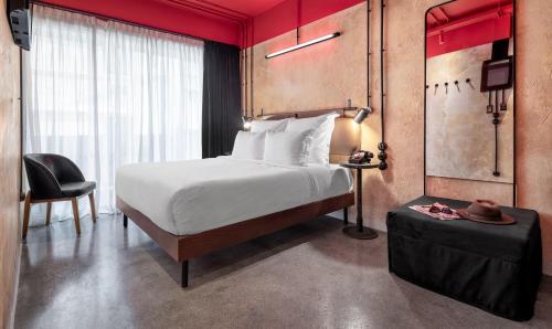 雅典Dave Red Athens, a member of Brown Hotels的配有一张床和一把椅子的酒店客房