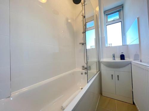 伦敦2 Bed- Belsize Park的带浴缸、水槽和淋浴的浴室