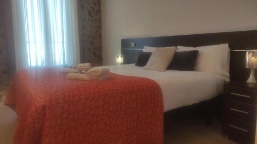 梅迪纳塞利Hostal Bavieca的一间卧室配有一张带红色毯子的大床