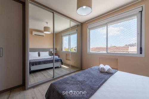 阿雷格里港Confortável apto em Porto Alegre/RS PRL0602的一间卧室设有一张床和一个大窗户