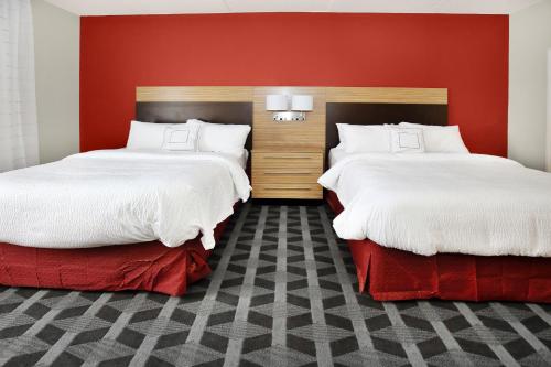 格罗夫城默瑟县格罗夫城/奥特莱斯万豪广场套房酒店的红色墙壁客房的两张床
