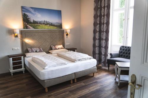 RossleithenVilla Bergzauber的卧室配有一张床,墙上挂有绘画作品