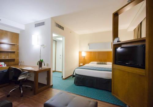 圣保罗伊斯坦广场波里尼酒店的酒店客房设有一张床、一张书桌和一台电视机。