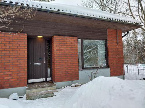 波尔沃Wera的雪中带黑色门的砖房