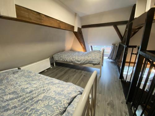 菲亚嫩Luxe en ruim appartement in Rijksmonument的铺有木地板的小客房内的两张床