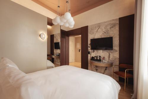 塞萨洛尼基Zenith Premium Suites的一间带白色床的卧室和一间浴室