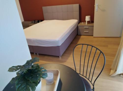 布兰肯贝赫Appartement Blankenberge的卧室配有1张床和1张桌子及椅子