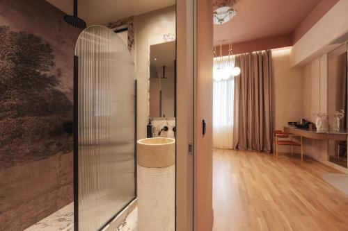 塞萨洛尼基Zenith Premium Suites的一间带玻璃淋浴和桌子的浴室