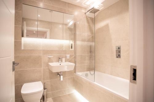 斯劳Deluxe Chic 1 2 Bed Apts near Heathrow Legoland Windsor Slough的浴室配有卫生间、盥洗盆和淋浴。