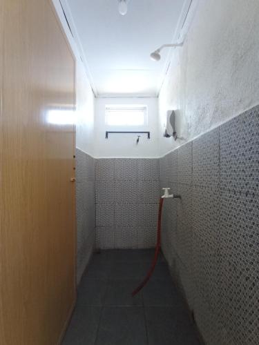 停泊岛海马潜水员旅舍的一间带红色软管淋浴的浴室