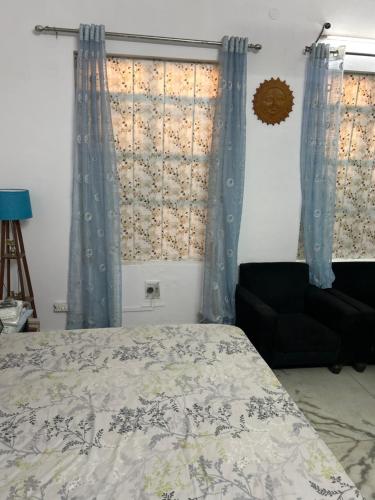 瓜廖尔Stay with Abhishek的一间卧室配有床、窗帘和椅子