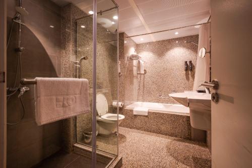 拉各斯Eko Hotel Suites的带淋浴、卫生间和盥洗盆的浴室
