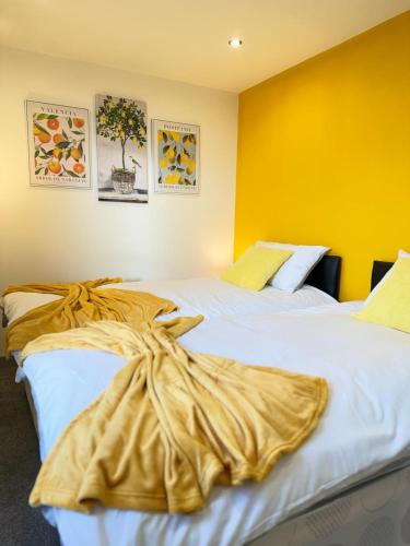 伊登Flat 401 Spacious Two Bedroom的黄色墙壁客房的两张床