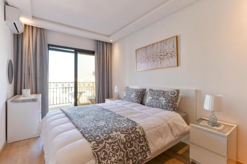 拉巴特Appartement Charmant & Cozy - Centre ville de Rabat的一间带大床的卧室和一个阳台