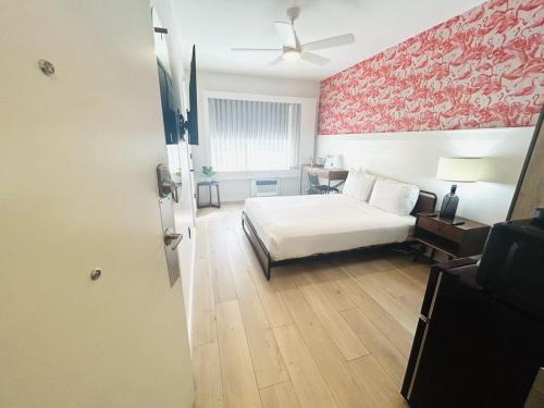 迈阿密海滩Greenview Hotel By Lowkl的一间卧室设有一张床和红色的墙壁