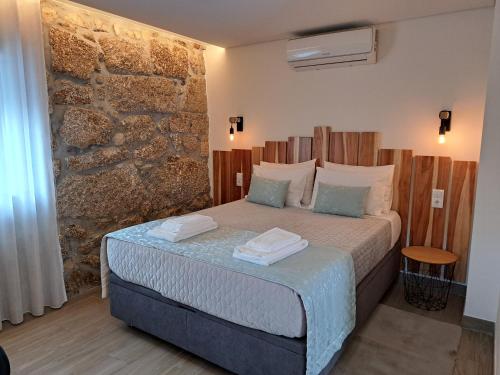 帕科斯费雷拉Agrafonte的卧室在石墙前配有一张床