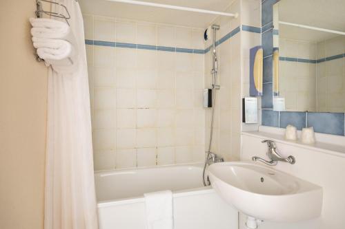 布里夫拉盖亚尔德西布瑞福戈雅德钟楼酒店的浴室配有盥洗盆和浴缸。