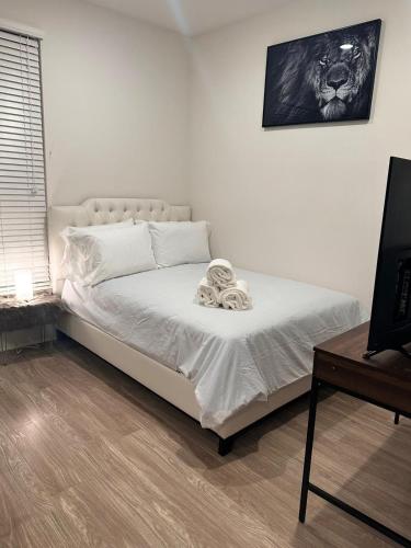 洛杉矶Cozy Studio Sunset FREE parking and WIFI的一间卧室配有一张带白色床单的床和一张书桌。