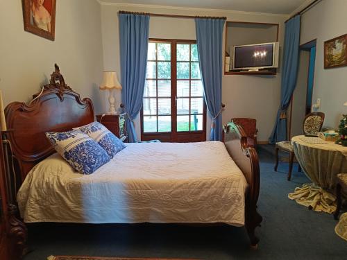 GauriacLe chez nous的一间卧室配有一张带蓝色窗帘的床和电视。