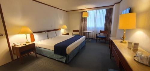 墨西哥城布里斯托酒店的酒店客房带一张床、一张桌子和椅子