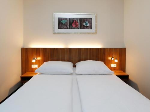 柏林B&B HOTEL Berlin-Mitte的一间卧室配有一张带两个白色枕头的大床