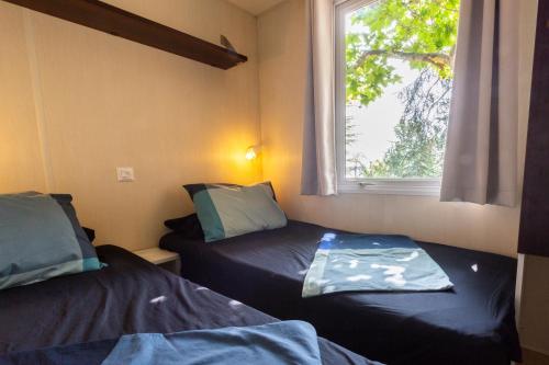 卡里拉厄尔远东野营简易别墅酒店的小房间设有两张床和窗户
