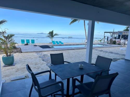 乌图罗阿Pension Irivai appartement "Uparu" 1 chambre bord de mer的一张桌子和椅子,享有海滩美景