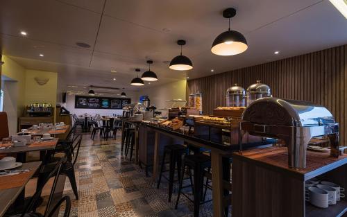 特鲁希略Casa Andina Standard Trujillo Plaza的餐厅设有酒吧和桌椅