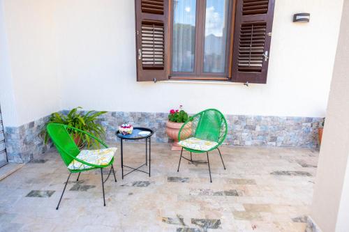 罗戈·格兰德Al Manzil的庭院设有两把椅子和一张桌子,种植了植物