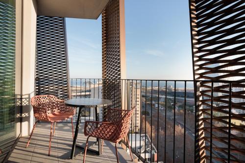巴塞罗那Tembo Barcelona的设有一个配有桌椅并享有美景的阳台。