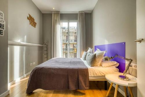 巴塞罗那Beautiful 4bd 4ba apartment in Eixample District的一间卧室配有一张大床和紫色床头板