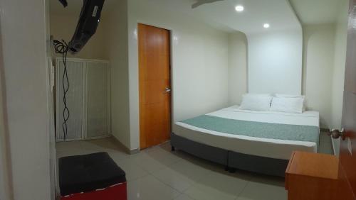 波哥大AW Connect Airport的一间小卧室,配有一张床和一扇木门