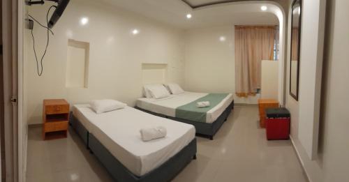 波哥大AW Connect Airport的酒店客房,设有两张床和镜子