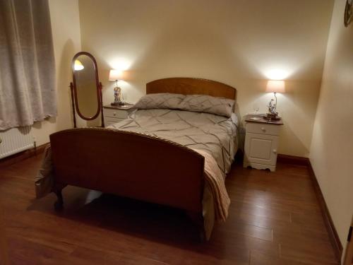 沃特福德Four Seasons的一间卧室配有一张带2个床头柜和镜子的床