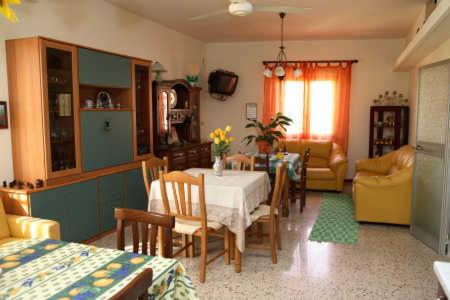 圣乔瓦尼镇B&B Villa el Tango的厨房以及带桌椅的起居室。