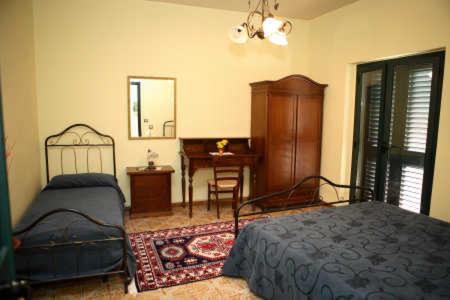 圣乔瓦尼镇B&B Villa el Tango的一间卧室配有一张床、一张桌子和一张书桌